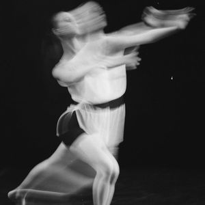 Blur motion of a person performing a dynamic stretch.