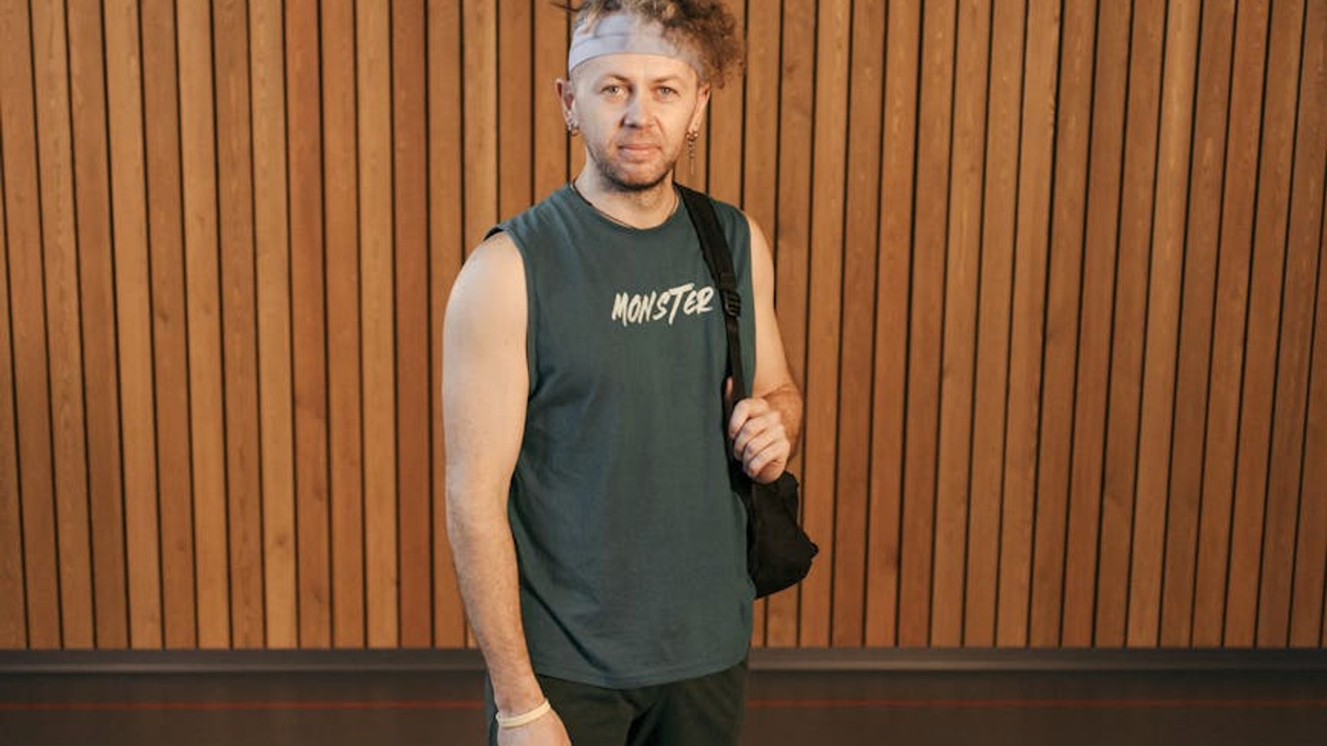 Man in a focused stance during a workout in a minimalist gym.