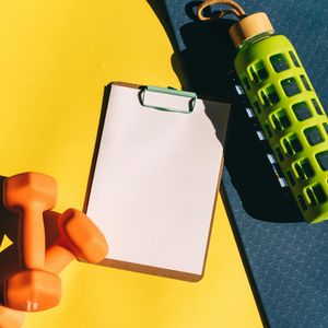 Minimalist home gym setup with a mat and dumbbells.